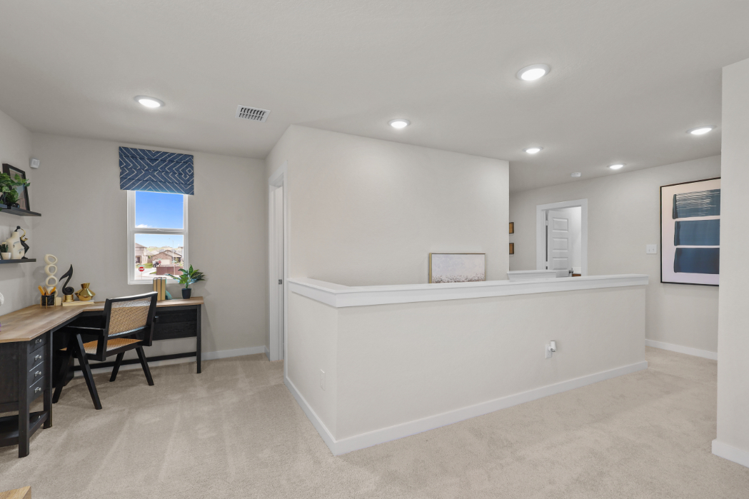 A large white room with a desk and chairs.