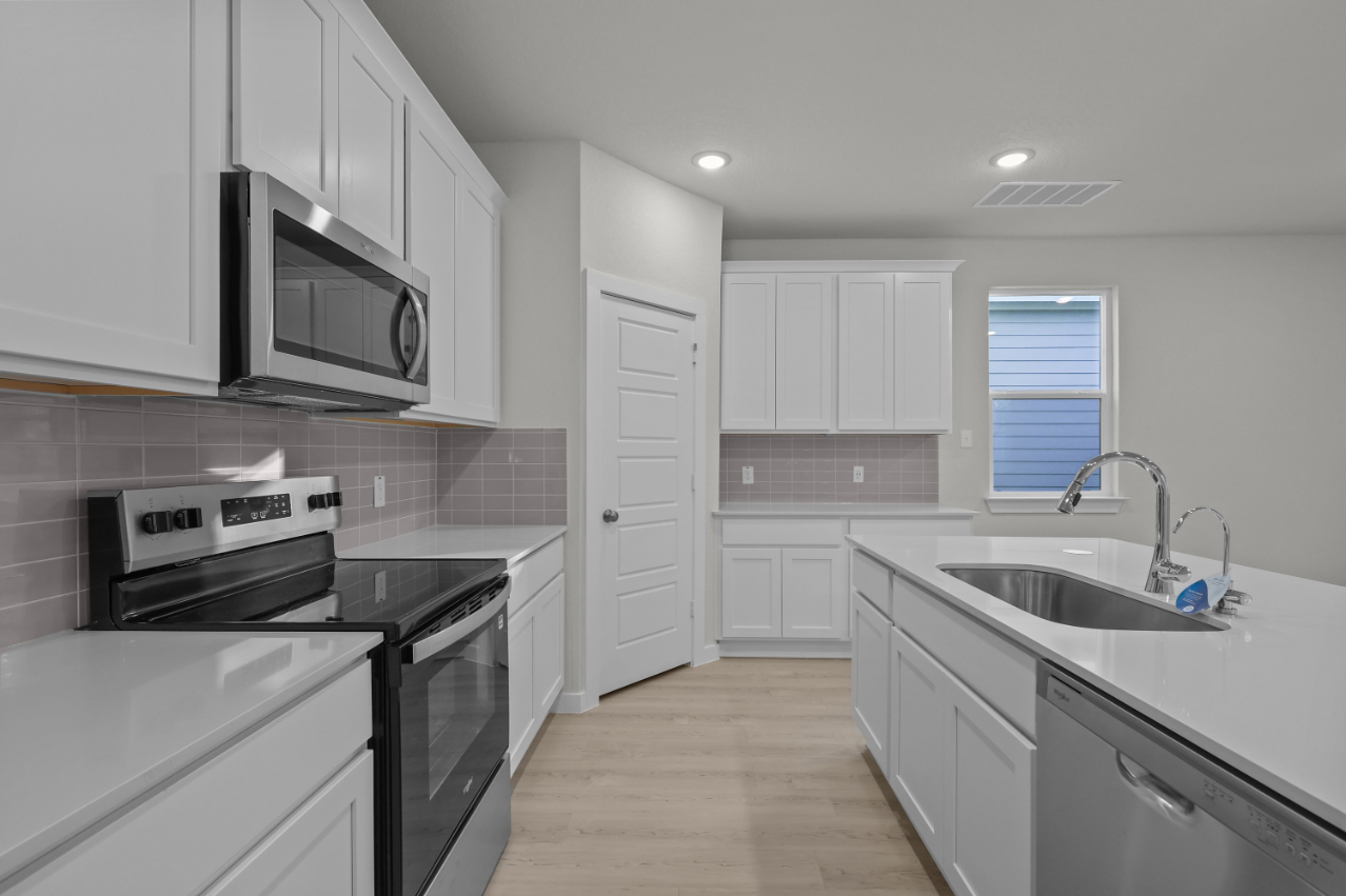 A kitchen with white cabinets.