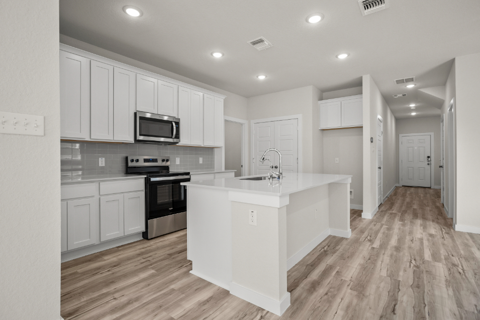 A kitchen with white cabinets.