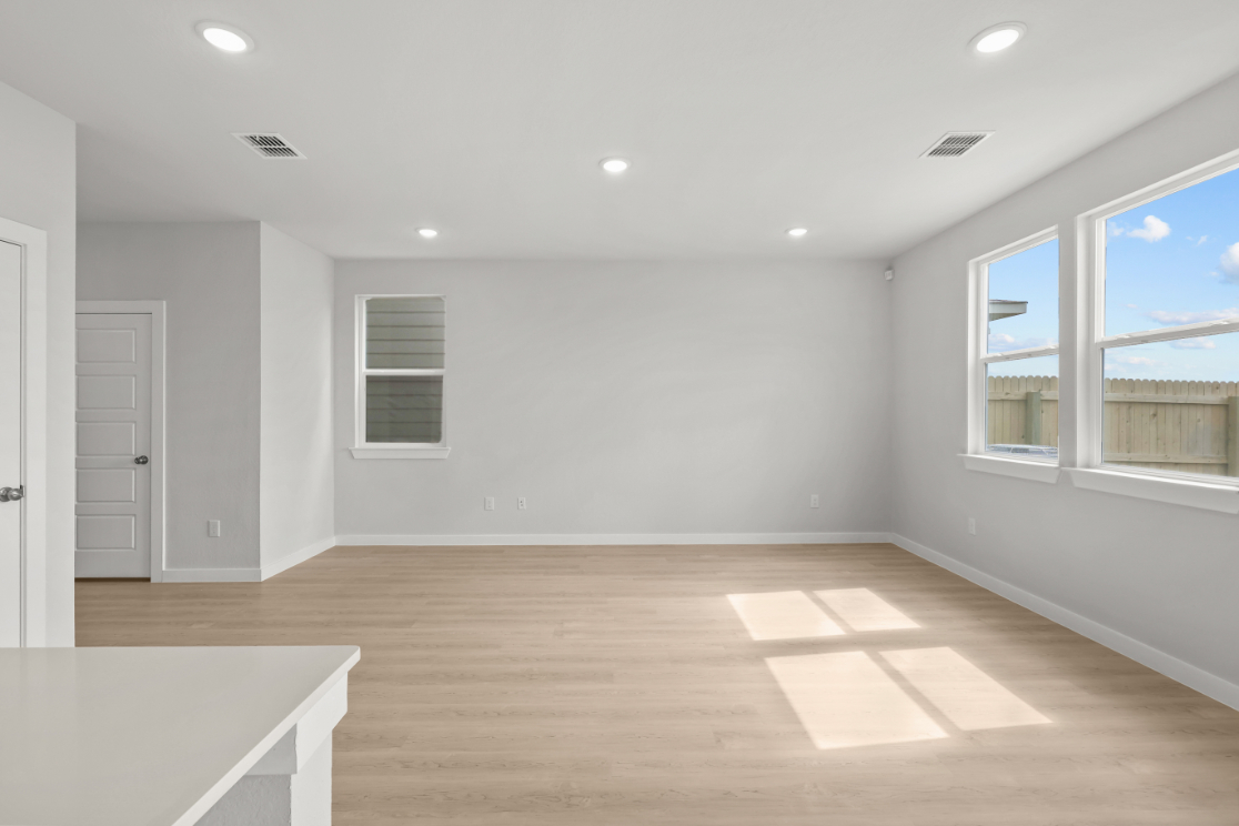 A room with a wood floor and windows.
