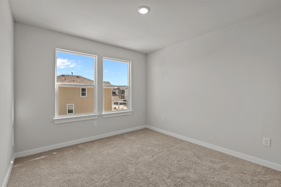 A room with a window and a carpet.