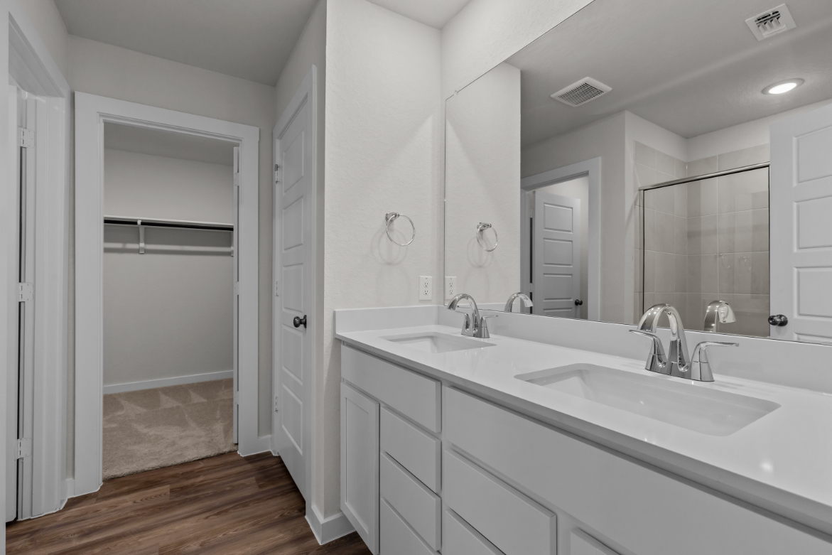 A bathroom with white cabinets.