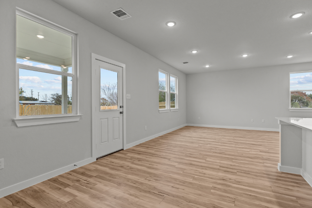 A room with a wood floor and windows.