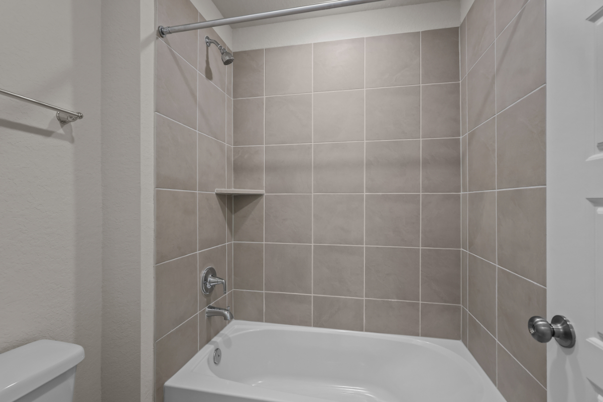 A bathroom with a bathtub and shower.