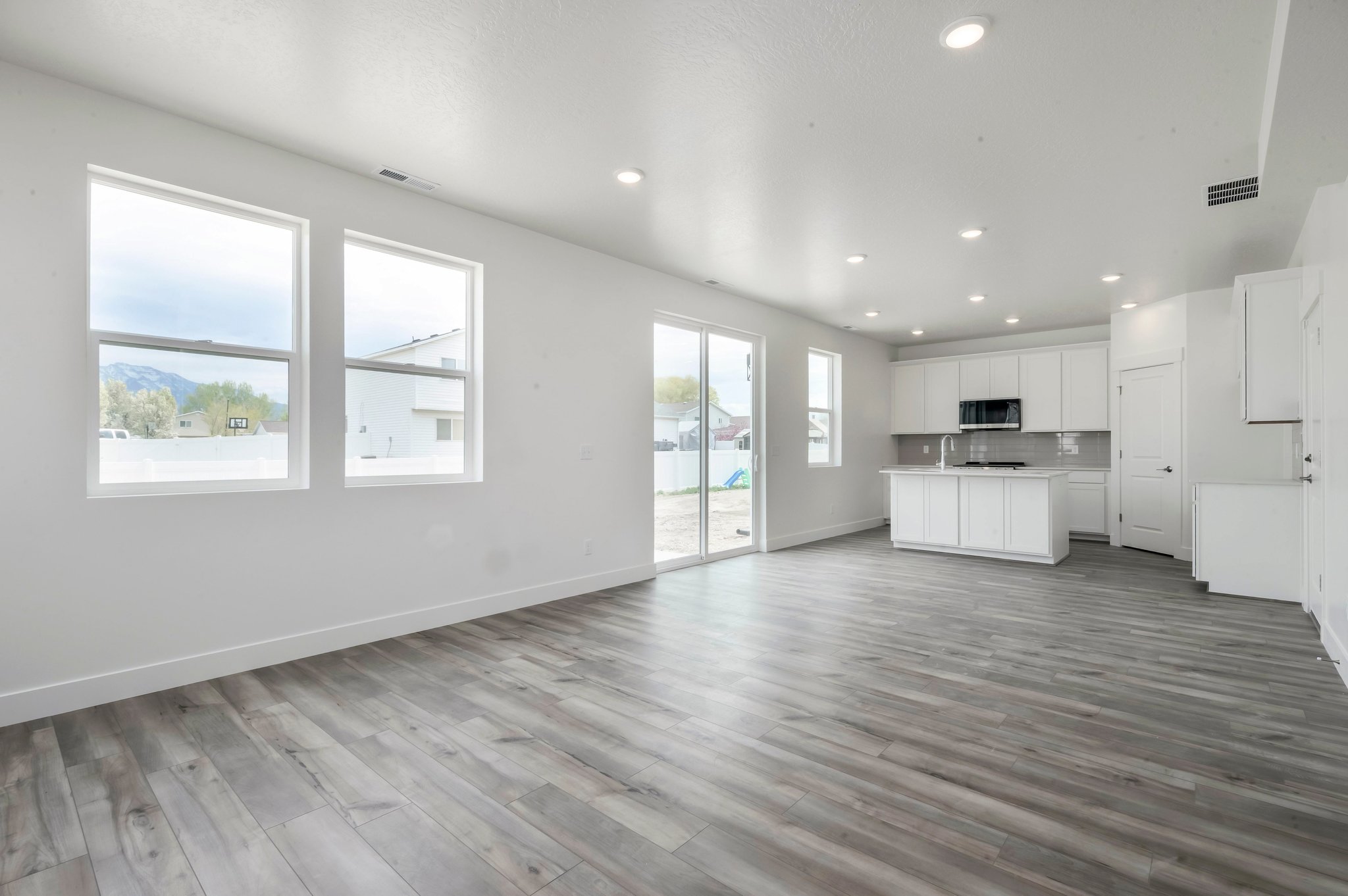 A room with white cabinets and a wood floor.