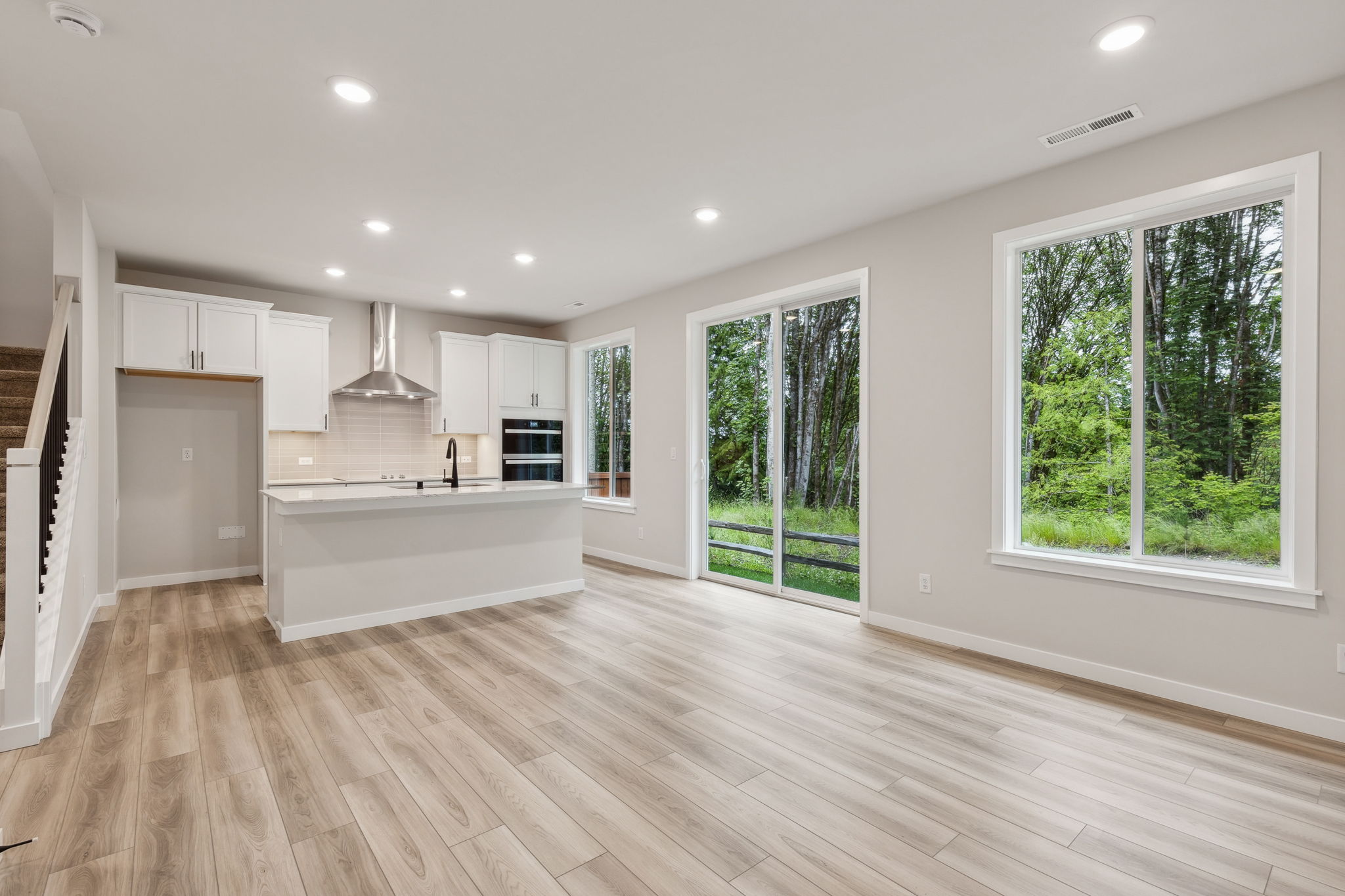 A large kitchen with a wood floor.