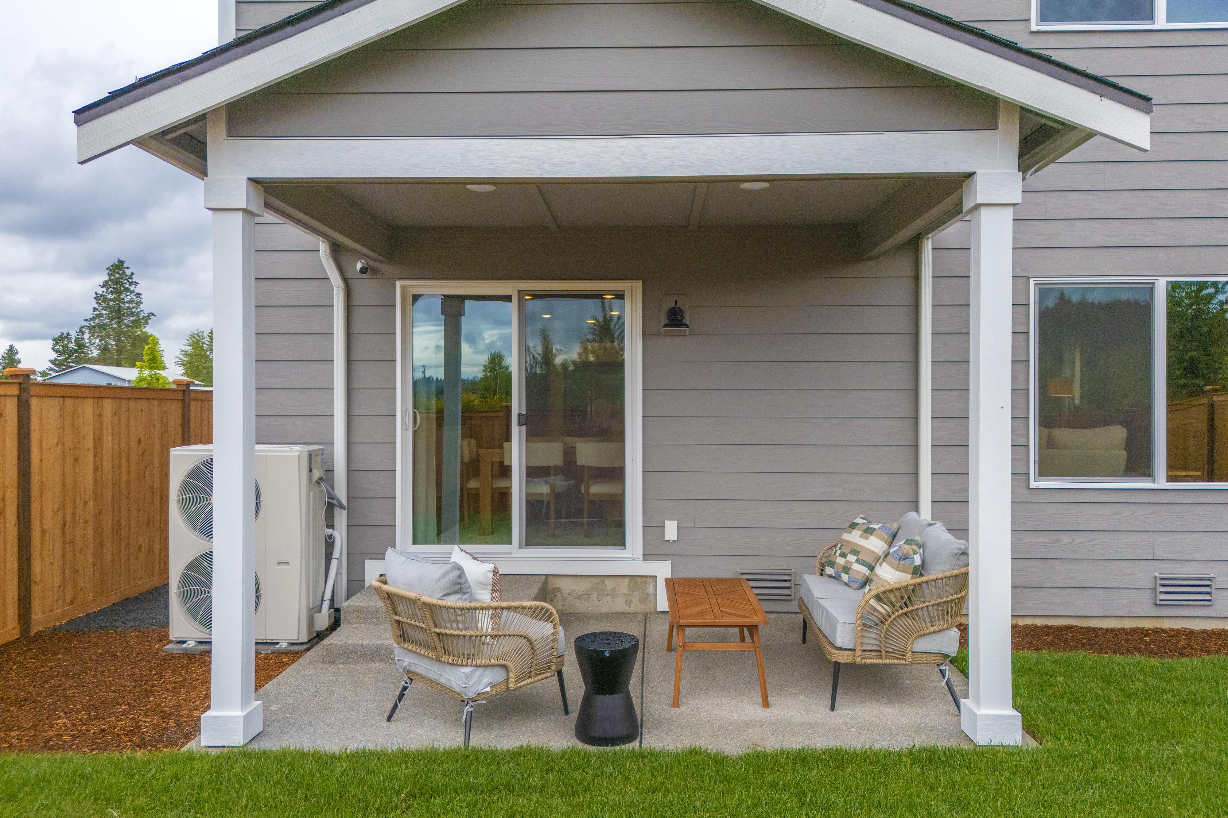 A house with a patio and a chair and a table outside.