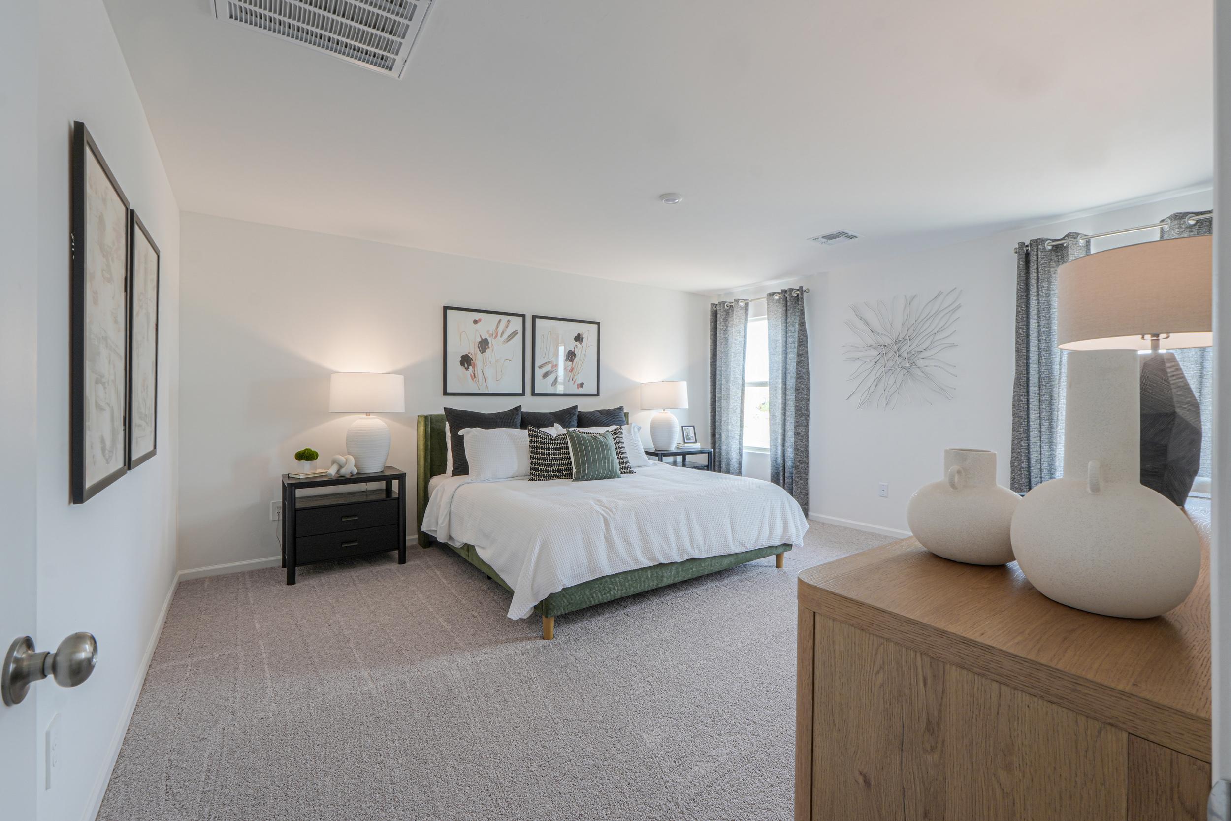 A bedroom with a bed and lamps.