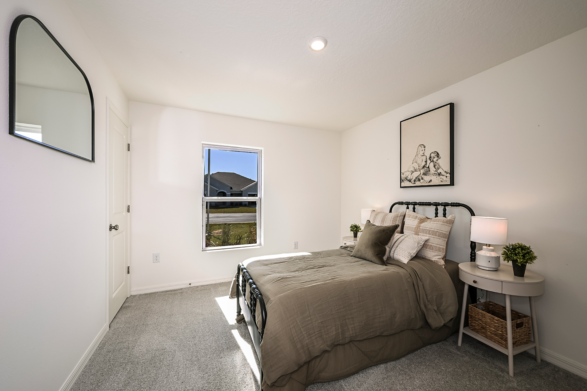 A bedroom with a bed and a mirror.