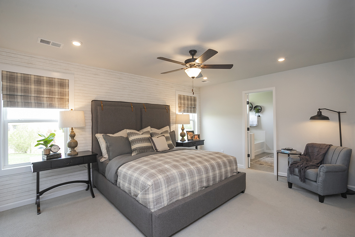 A bedroom with a bed and a fan.