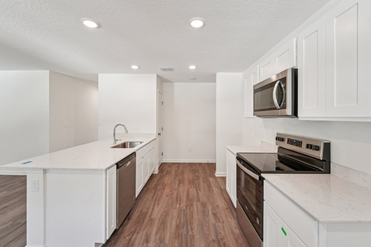 A kitchen with white cabinets.