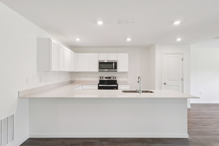 A kitchen with white cabinets.