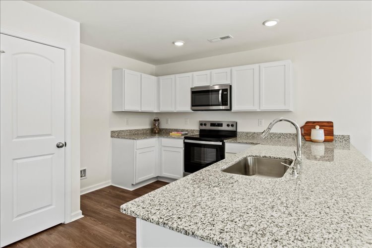 A kitchen with white cabinets.